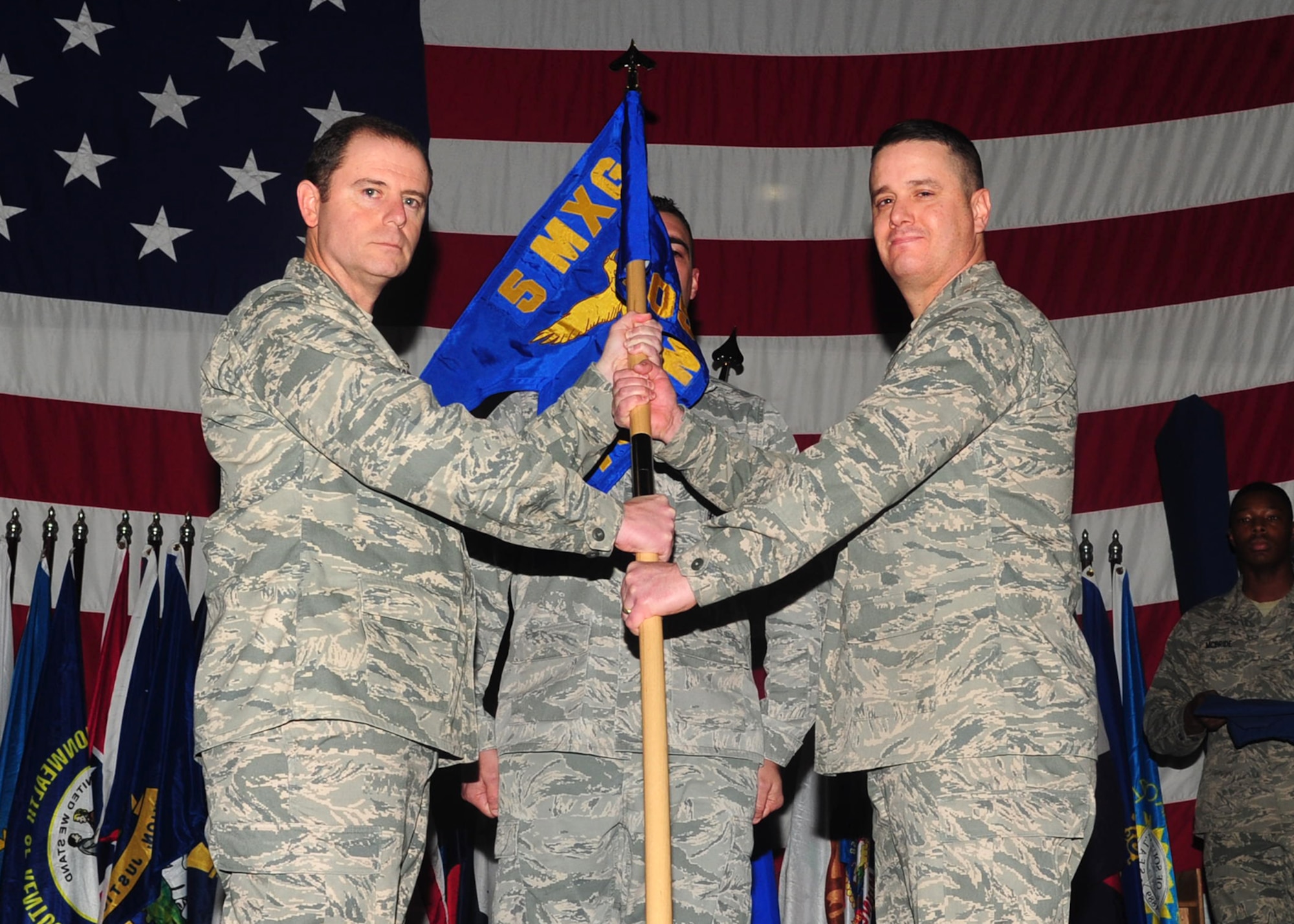 MINOT AIR FORCE BASE, N.D. -- Col. Eric Froehlich, 5th Maintenance Group commander, hands over the 705th Munitions Squadron guidon  to Lt. Col. Jimmy Soles, 705th MUNS commander, during an activation ceremony here Dec. 2. The 17th Munitions Squadron was realigned as the 705th MUNS, falling under the 5th Bomb Wing and Air Force Global Strike Command. (U.S. Air Force photo/Senior Airman Michael J. Veloz)