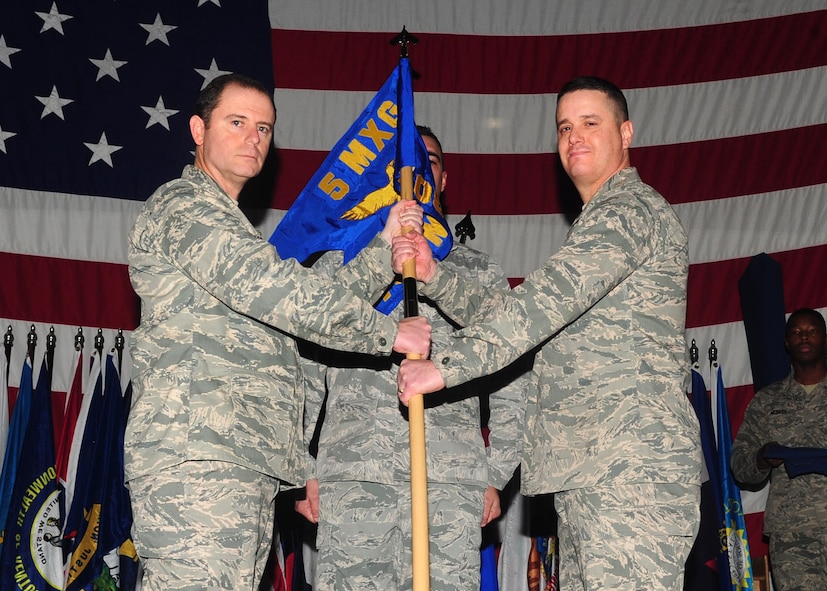 MINOT AIR FORCE BASE, N.D. -- Col. Eric Froehlich, 5th Maintenance Group commander, hands over the 705th Munitions Squadron guidon  to Lt. Col. Jimmy Soles, 705th MUNS commander, during an activation ceremony here Dec. 2. The 17th Munitions Squadron was realigned as the 705th MUNS, falling under the 5th Bomb Wing and Air Force Global Strike Command. (U.S. Air Force photo/Senior Airman Michael J. Veloz)