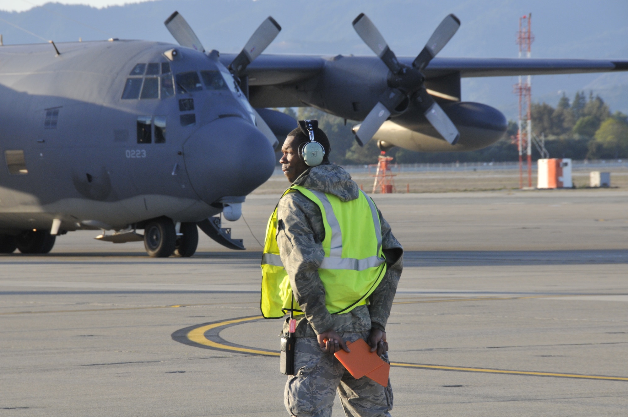 California Air National Guard Senior Airman Tobias Levene, a crew chief assigned to the 129th Aircraft Maintenance Group, guides a MC-130P Combat Shadow aircraft on the flight line for takeoff, at Moffett Federal Airfield, Calif., Dec. 4, 2011. The flight is part of the 129 RQW Operational Readiness Inspection in which an Air Combat Command inspector general team tests the unit's wartime capabilities and readiness to deploy. (Air National Guard photo by Staff Sgt. Kim E. Ramirez)