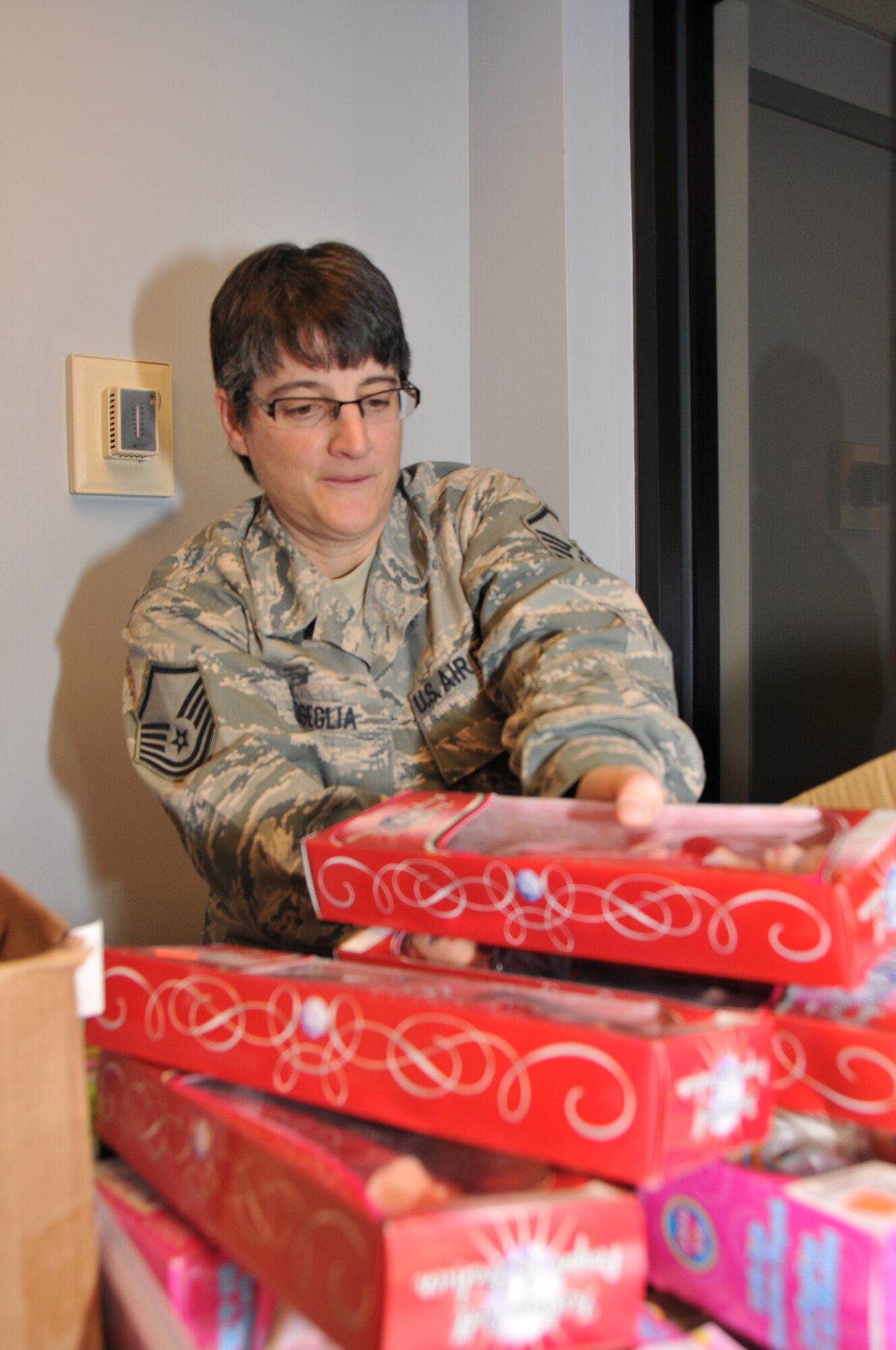 Master Sgt. Laura Coseglia, 512th  Airman & Family Readiness Office director, unpack children’s holiday gift items donated by Operation Homefront at the Dover Air Force Base, Del., theater before the quarterly commander’s call Dec. 3, 2011. Formed in Feb. 2002, Operation Homefront assists American military personnel and their families who have unmet needs due to financial hardship, death, injury, or physical or mental detriment as a result of service in Iraq or Afghanistan. (U.S. Air Force photo by Staff Sgt. Andria J. Allmond)