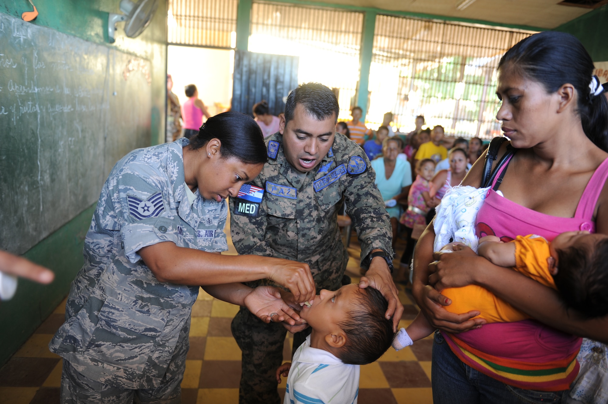 Tech. Sgt. Michelle James, from Joint Task Force-Bravo Medical Element and Honduran Army Sgt. Maj. Ovidio Paz-lagos, a nurse from the Honduran Surgeon Generals Office, give anti-parasitic medication to a Honduran boy during a Medical Readiness Training Exercise Nov. 30, 2011, in the department of Choluteca, Honduras.  (U.S. Air Force photo/Tech. Sgt. Matthew McGovern)    