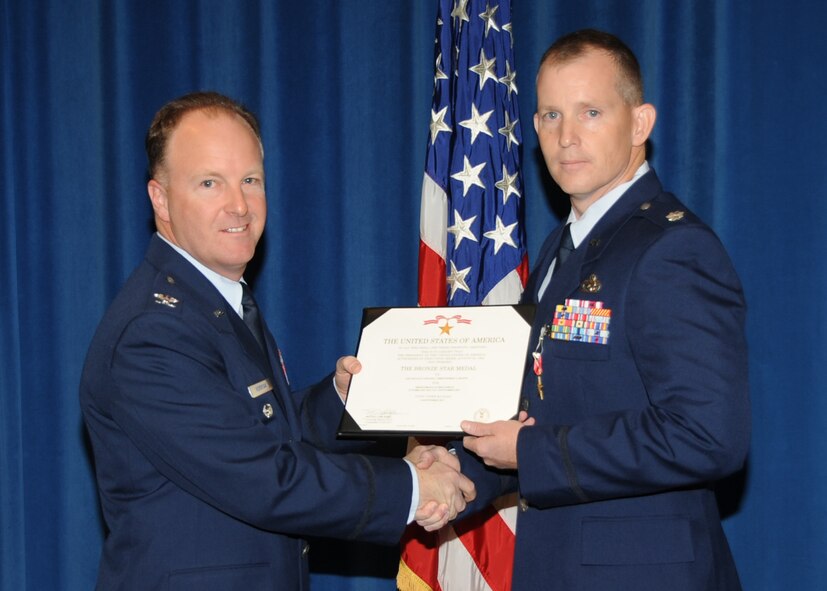 Col. David Hornyak, 377th Air Base Wing vice commander, presents a bronze star certificate to Lt. Col. Christopher Boone, 377th Logistics Readiness Squadron commander, during a ceremony Monday at Kirtland Air Force Base. Boone earned the honor for his accomplishments while deployed.  U.S. Air Force Photo by Dennis Carlson.