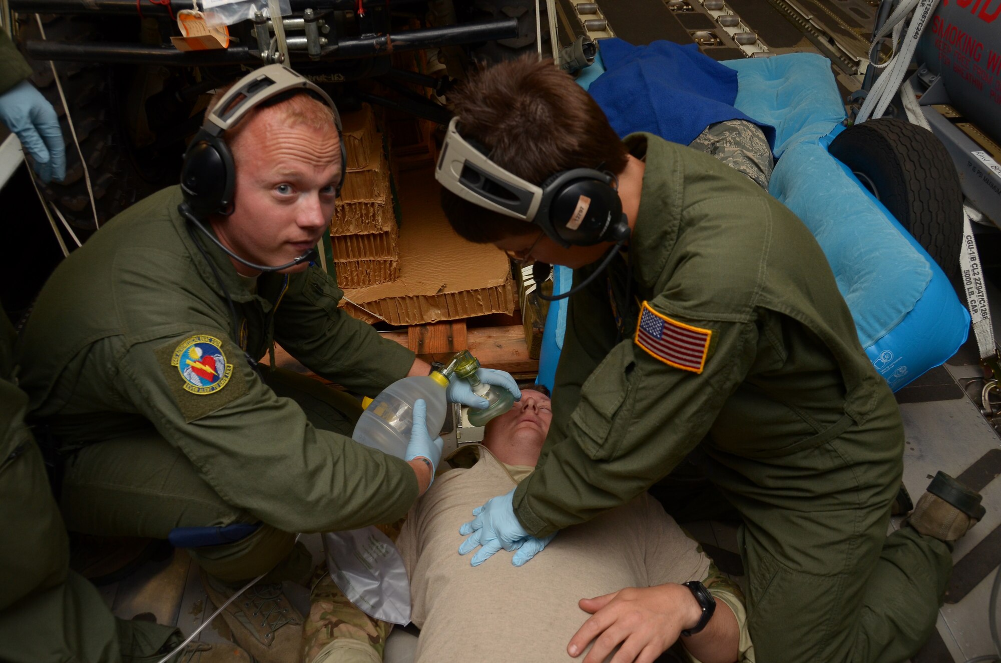 WRIGHT-PATTERSON AIR FORCE BASE, Ohio – Tech. Sgt. Mike Flaata and Tech. Sgt. Amanda Hostetter, 445th Aeromedical Evacuation Squadron, run through a medical scenario as part of a training exercise during their flight home from South Africa Oct. 4. Master Sgt. John Lane, 212th Rescue Squadron, 176th Wing, Joint Base-Elmendorf-Richardson, Alaska, role plays the patient they are assisting. (U.S. Air Force photo/Senior Airman Mikhail Berlin)