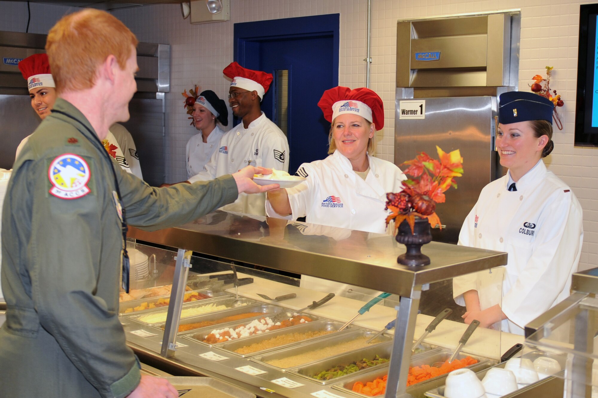 U.S. Air Force Chief Master Sgt. Suzan Sangster, 55th Wing command chief, serves a plate for U.S. Air Force Maj. Robert Stevens, 1st Airborne Command and Control Squadron navigator, at the Offutt Air Force Base, Neb. Campisi Alert Dining Facility, Nov. 24. Leaders from the 55th Wing took time on Thanksgiving Day to say thank you to service members by serving them a traditional holiday meal. (Air Force photo by Jeff Gates)