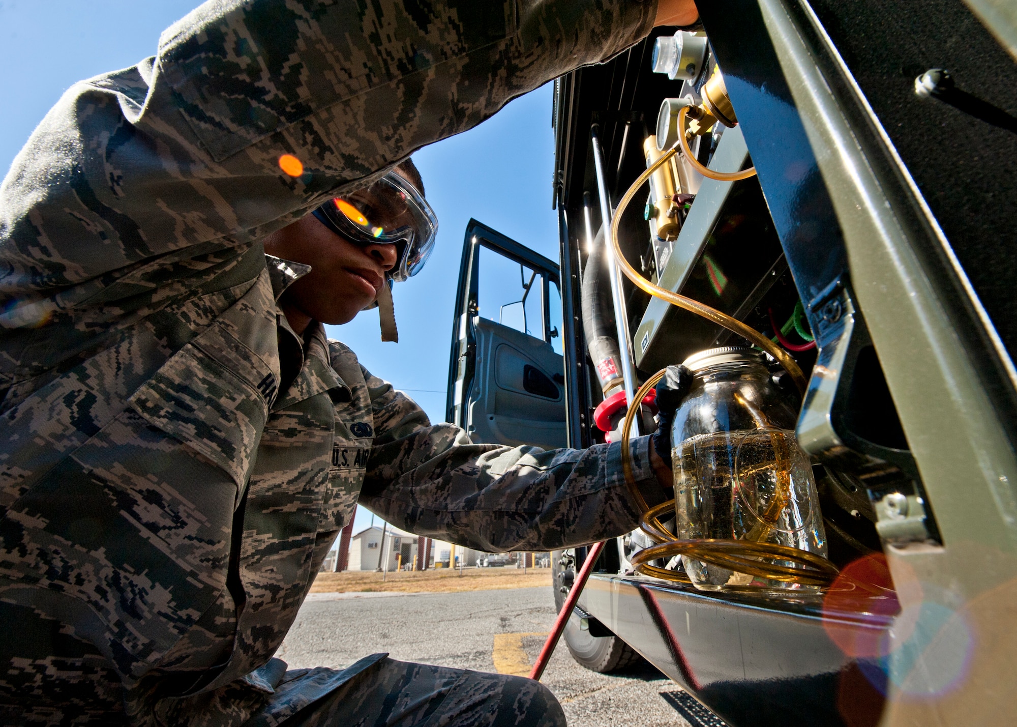 Airman 1st Class Troy Hall, with the 96th Logistics Readiness Squadron, takes a quart jar sample of JP-8 from an Air Force R-11 tanker truck to be tested in the Eglin fuels lab. Airmen in the Eglin fuels lab evaluate more than 200 aviation and ground fuel samples each month.  These steps are taken to ensure water, additives and sediment amounts are at or below the proper levels.  (U.S. Air Force photo/Samuel King Jr.)