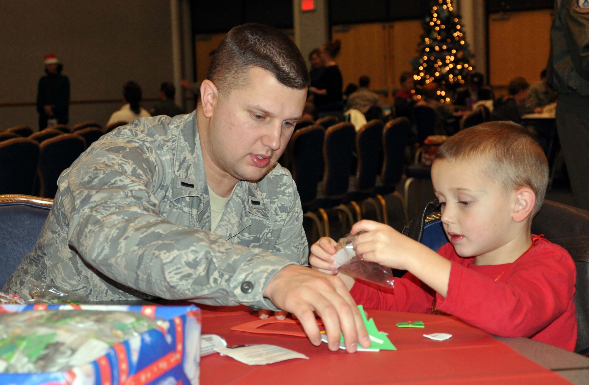 First Lt. Travis Potter helps his son, Blake, create a holiday ornament during a holiday event for children at McConnell Air Force Base, Kan. Dec. 4.  The 931st Air Refueling Group hosted the event, which provided Airmen, their spouses and children an afternoon of making crafts, enjoying holiday treats, and spending some time with Santa.  (U.S. Air Force photo by 1st Lt. Zach Anderson)