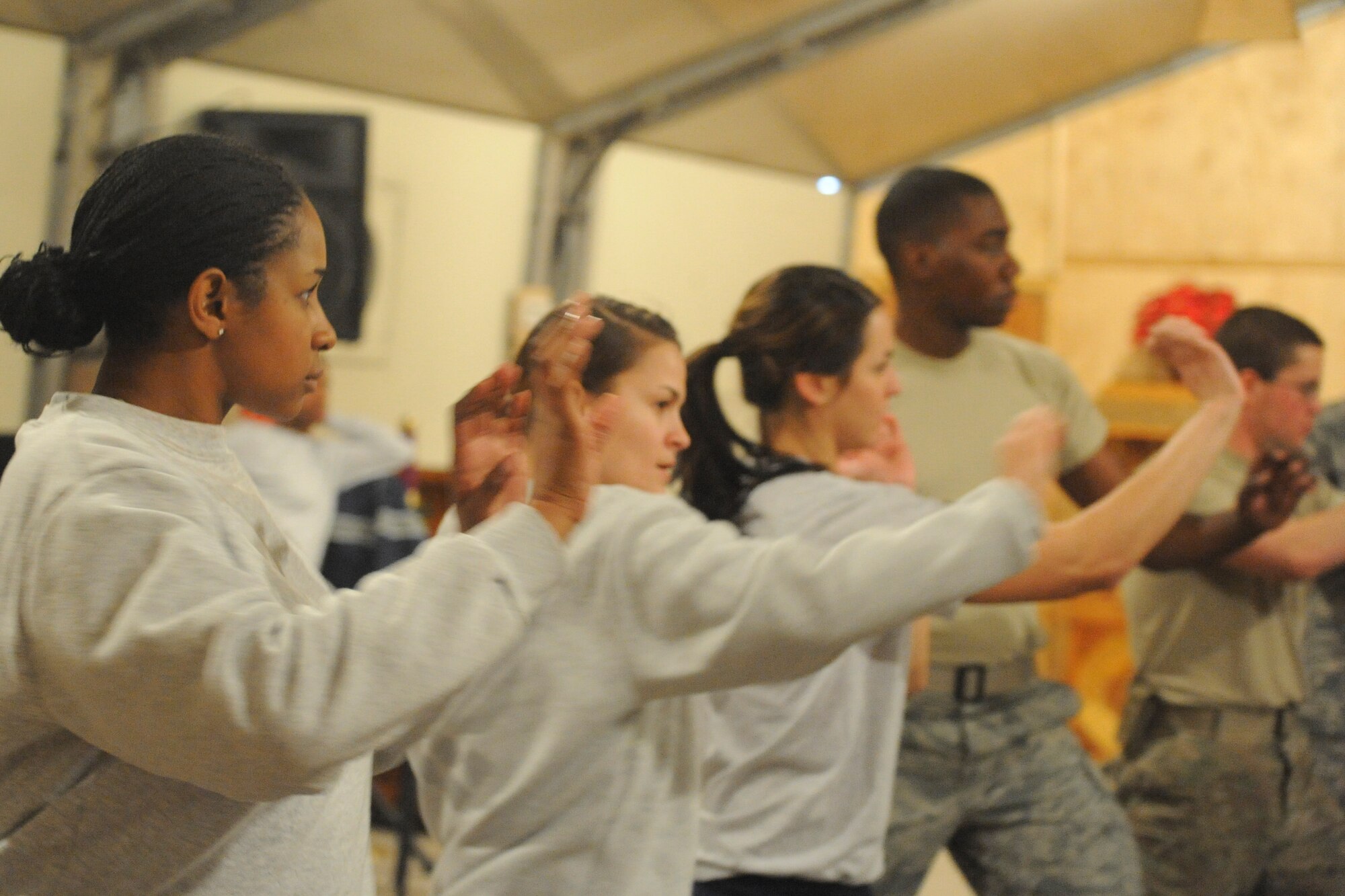 A group of students practice palm strikes during a self-defense class here Dec. 3, 2011. The students learned basic blocking and striking techniques during the three-hour class. A second class, which takes place Dec. 10, is open only to females. This class will equip students with more advanced self-defense skills. (U.S. Air Force photo/Tech. Sgt. Tammie Moore)