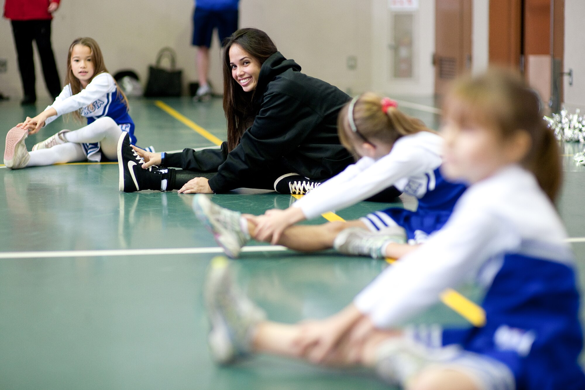 YOKOTA AIR BASE, Japan -- Stephanie, of the Marlins Mermaids, stretches with participants during a dance clinic held at the Yokota Youth Center, Dec. 3, 2011. The Mermaids, along with Billy the Marlin and Marlins players, held activities such as a baseball clinic, a dance clinic and meet and greets, sponsored by Armed Forces Entertainment. (U.S. Air Force photo/Osakabe Yasuo)