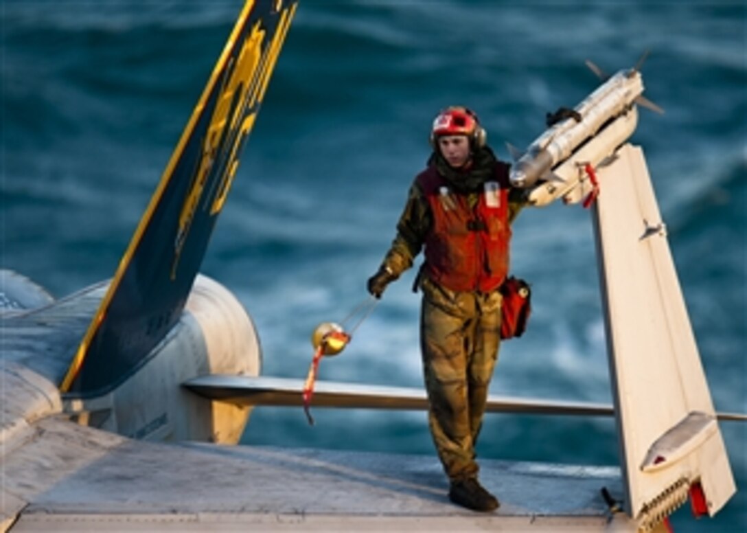 A U.S. Navy sailor removes the cap from an AIM-9 missile attached to an F/A-18C Hornet aircraft aboard the aircraft carrier USS John C. Stennis (CVN 74) in the Arabian Gulf on Dec. 3, 2011.  The John C. Stennis is deployed to the U.S. 5th Fleet area of responsibility conducting maritime security operations and support missions as part of Operations Enduring Freedom and New Dawn.  