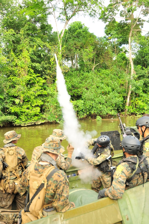 A U.S. Marine show a member of the Guatemalan Naval Special Forces how to shoot a flare in Santo Tomas.  The flare is used to mark a position Dec. 6. the U.S. Marines attached to a Special Purpose Marine Air Ground Task Force (SPMAGTF).::r::::n:: They are participating in the SMEE exchanges as a part of Amphibious-Southern Partnership Station 2012 (AMPHIB-SPS 12), an annual deployment of U.S. military teams to the U.S. Southern Command area of responsibility. ::r::::n::(U.S. Navy photo by Mass Communication Specialist 1st Class Isaiah Sellers III/Released)