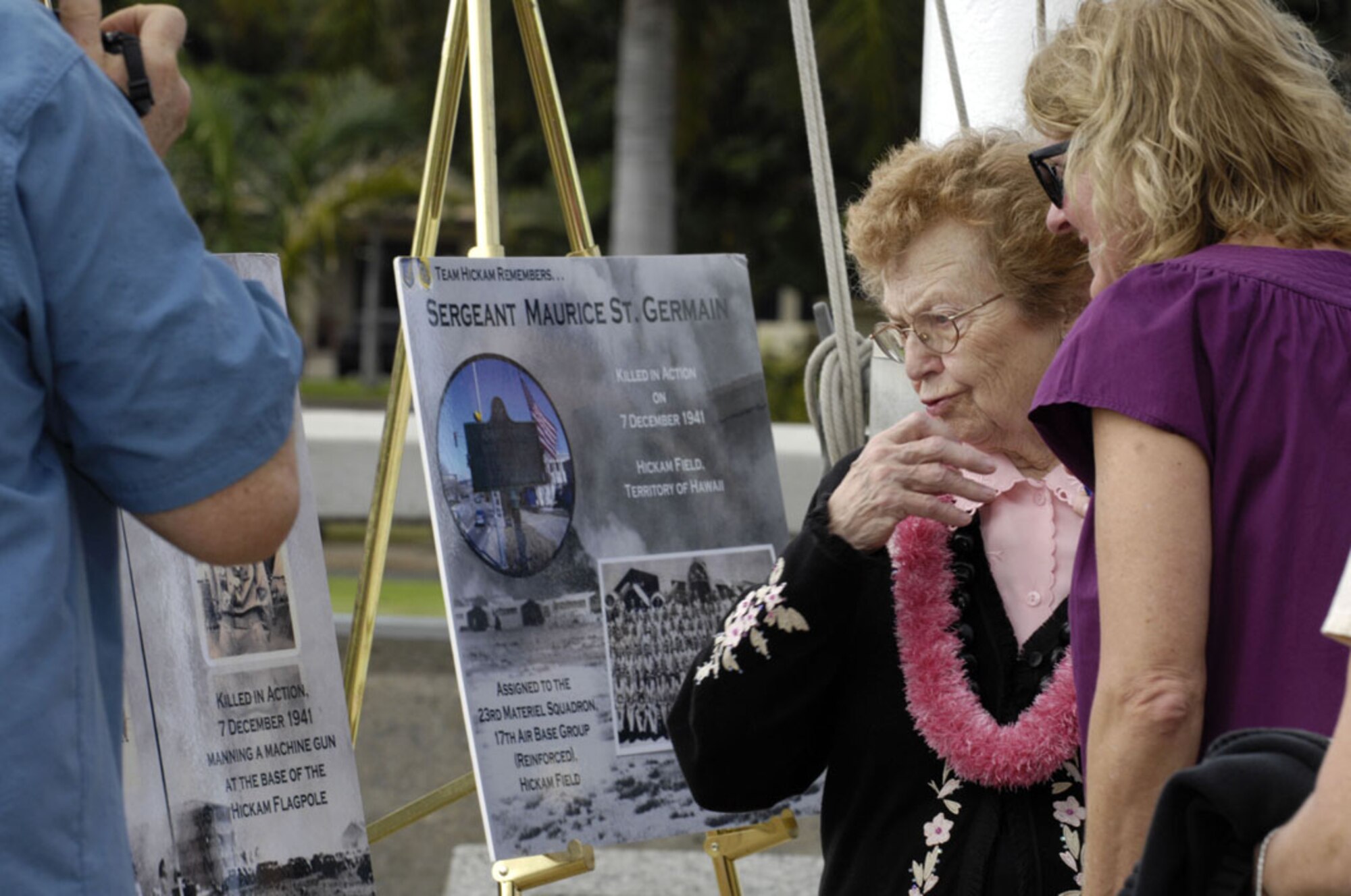Stella Russell looks at a poster of her brother, Private Joesph J. "Little Joe" Jedrysik, during a ceremony at the Joint Base Pearl Harbor-Hickam flagpole at Atterbury Circle on Dec. 6, 2011. Jedrysik was a protestant chaplains assistant assigned to the 17th Air Base Group, Hickam Field, Territory of Hawaii, and was killed in action on Dec. 7, 1941 while manning a machine gun at the base of the Hickam flagpole. (U.S. Navy photo/David D. Underwood, Jr.)