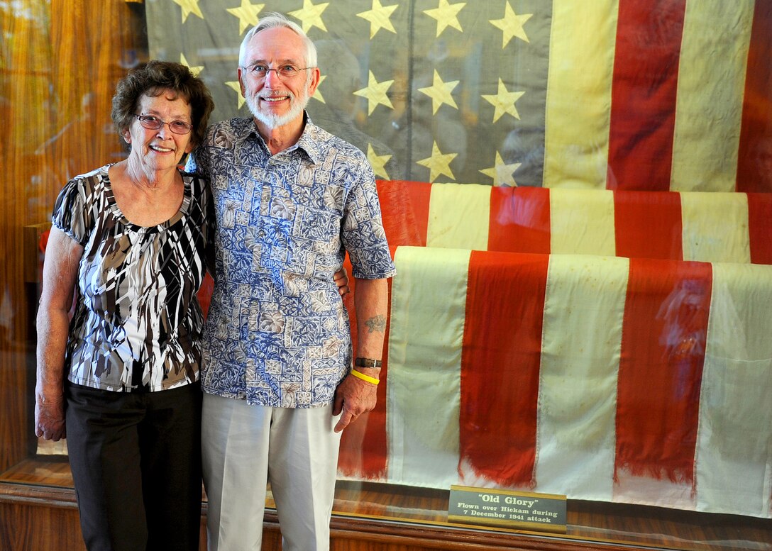 Hickam Field survivors Deloris Anderson and Larry Bush pose for a photo in front of Old Glory, the U.S. flag flown at Hickam Field during the attack on Dec. 7, 1941, at the Courtyard of Heroes, Joint Base Pearl Harbor-Hickam, Hawaii, Dec. 5, 2011.  As children of an Airman stationed at Hickam Field, the siblings who were only 5- and 8-, were home Dec. 7. 1941 and survived the sudden attacks by the Japanese. The siblings visited the base where 70 years ago they survived, ahead of the 70th Anniversary commemoration of the attacks on U.S. military forces stationed at Oahu. (U.S. Air Force photo/Tech. Sgt. Jerome S. Tayborn/Released)