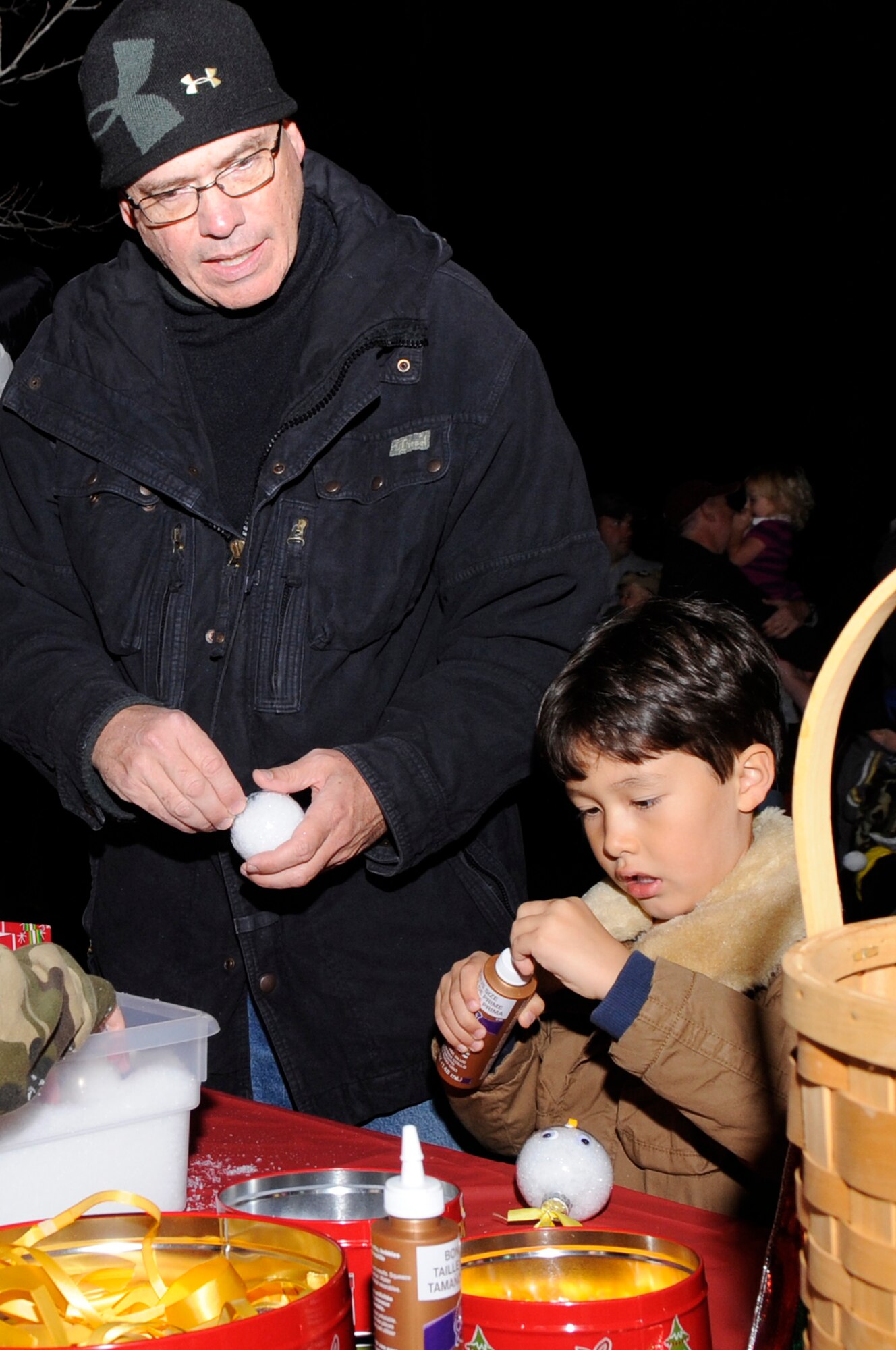 VANDENBERG AIR FORCE BASE, Calif. – Master Sgt. Kevin Hasslin, 30th Logistics Readiness Squadron production superintendent, crafts some ornaments with his son Taeyang at the Christmas tree lighting ceremony here Monday, Dec. 5, 2011. Christmas ornaments and yellow ribbons will be available to the entire Vandenberg Air Force Base community at 345 Oceanview Ave. until Dec. 25 to be placed on the tree for deployed loved ones. (U.S. Air Force photo/ Tech Sgt. Scottie T. McCord)