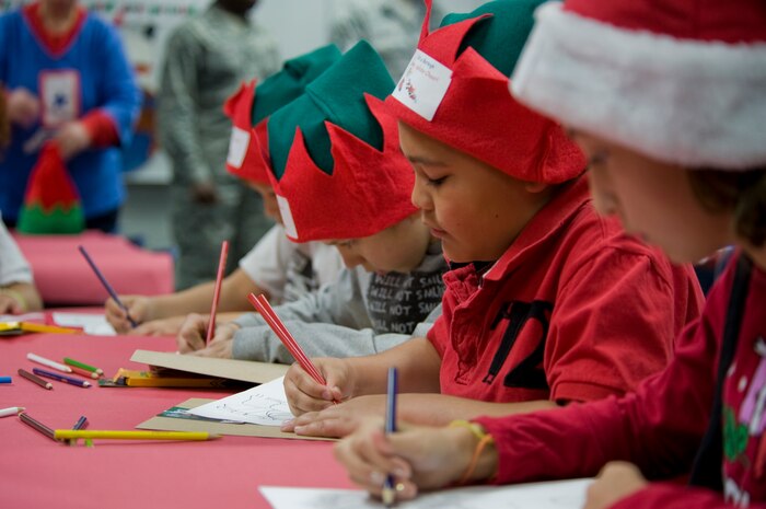 Children color pictures for their deployed parents Dec. 2, 2011, on Nellis Air Force Base, Nev. Blue Star Mothers and Santa Claus assisted students from Lomie Heard Elementary Schoo as they stuffed stockings and created care packages for their deployed parents.  (U.S Air Force photo by Senior Airman Stephanie Rubi/Released)