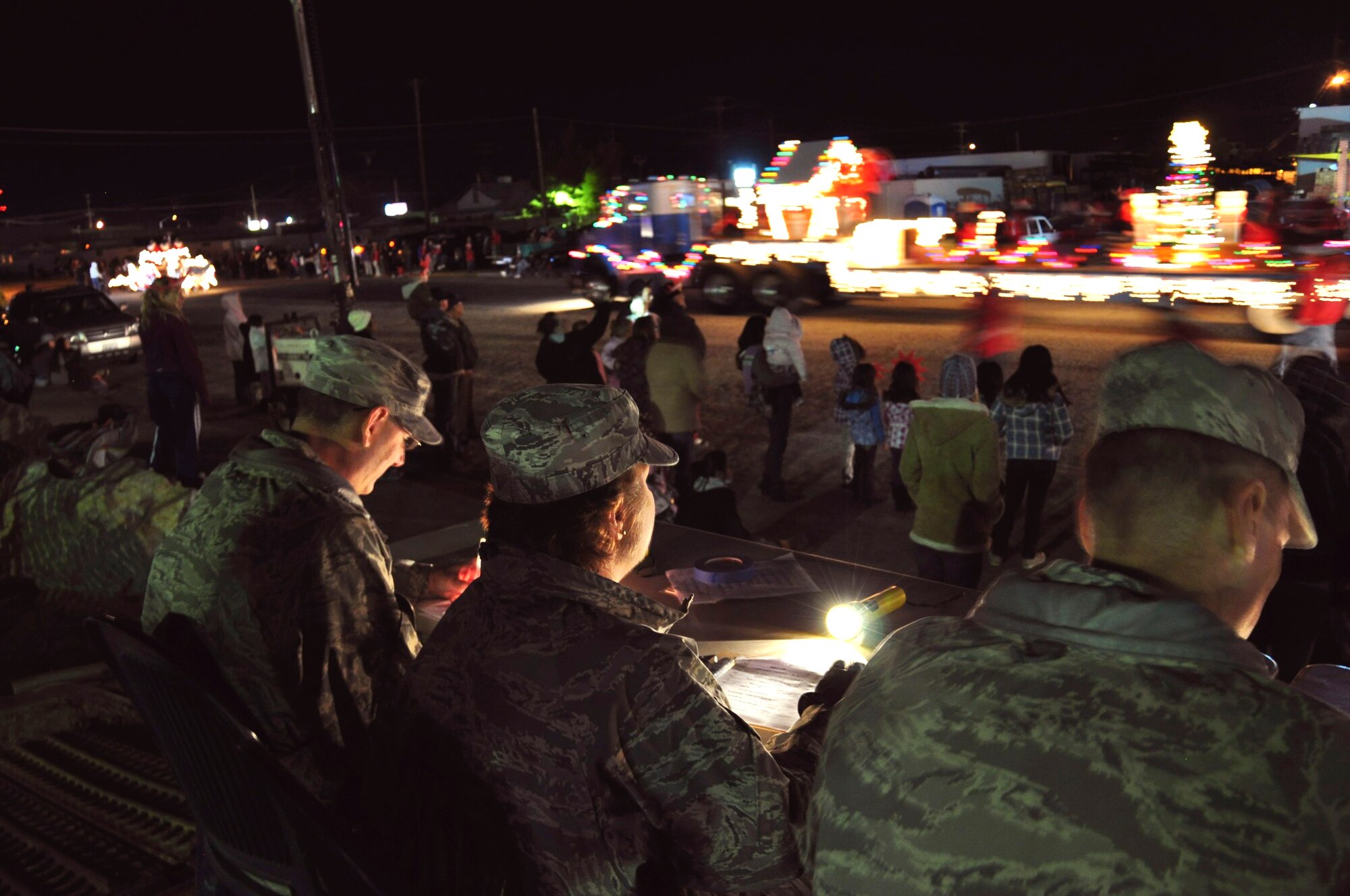Edwards AFB chief master sergeants (from left) David VanVlack, Air Force Operational Test and Evaluation Center Det. 1, Rhonda Buening, 95th Mission Support Group and Gregory Bobzin, 412th Aircraft Maintenance Squadron, judge floats in the Rosamond Holiday Parade of Lights, Dec. 3. The event featured about 30 floats from private organizations and Rosamond businesses. For the past 17 years, Team Edwards members have participated as judges. (U.S. Air Force photo/Mike Strickler)