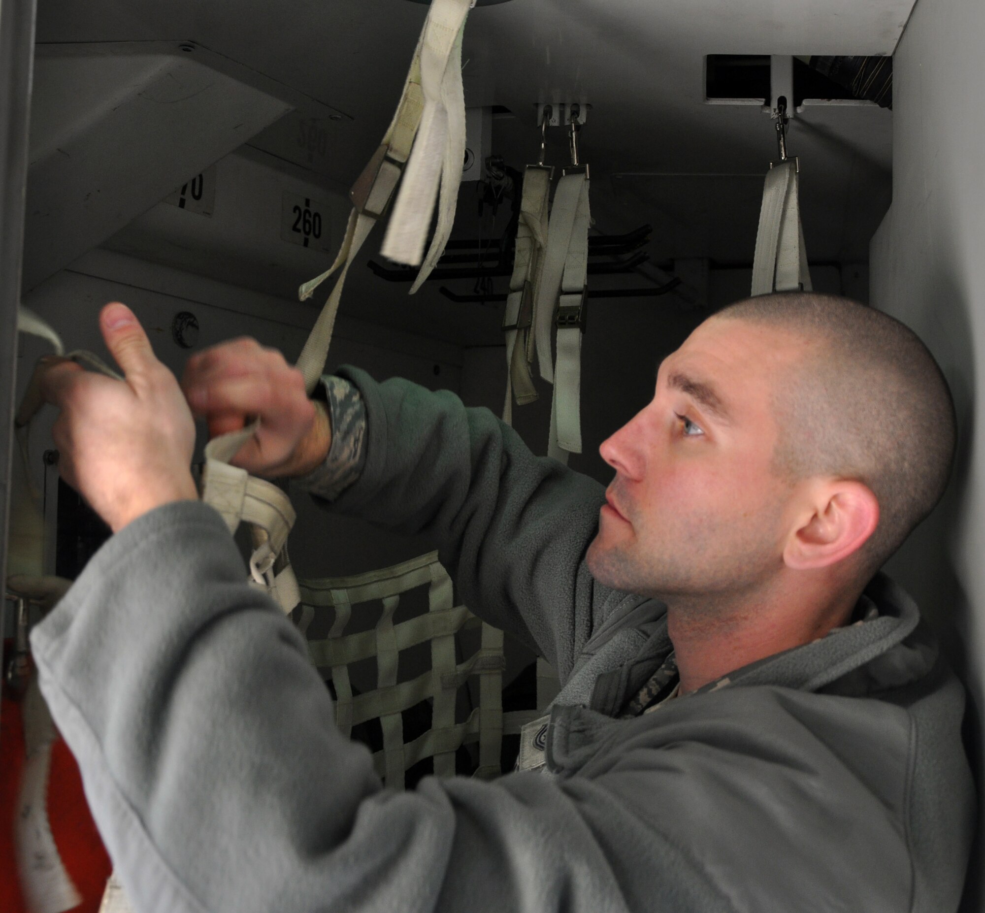 Tech. Sgt. Rick Rodabaugh, 446th Aircraft Maintenance Squadron crew chief here, replaces an equipment locker storage net on a C-17 Globemaster III at McChord Field Dec. 4.  Reservists from the 446th AMXS have focused their annual training on reducing delayed discrepancies for McChord's aircraft fleet through a targeted maintenance team program.  (U.S. Air Force photo by Tech. Sgt. Elizabeth Moody)