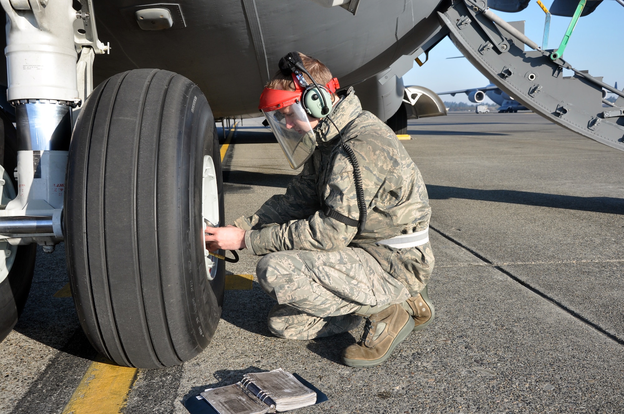 Senior Airman Leland Sivanish, 446th Aircraft Maintenance Squadron crew chief here, checks nose tire air pressure for a C-17 Globemaster III at McChord Field Dec. 4.  Sivanish is part of the 446th AMXS targeted maintenance team, working delayed discrepancies for aircraft. (U.S. Air Force photo by Tech. Sgt. Elizabeth Moody)