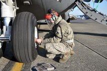 Senior Airman Leland Sivanish, 446th Aircraft Maintenance Squadron crew chief here, checks nose tire air pressure for a C-17 Globemaster III at McChord Field Dec. 4.  Sivanish is part of the 446th AMXS targeted maintenance team, working delayed discrepancies for aircraft. (U.S. Air Force photo by Tech. Sgt. Elizabeth Moody)