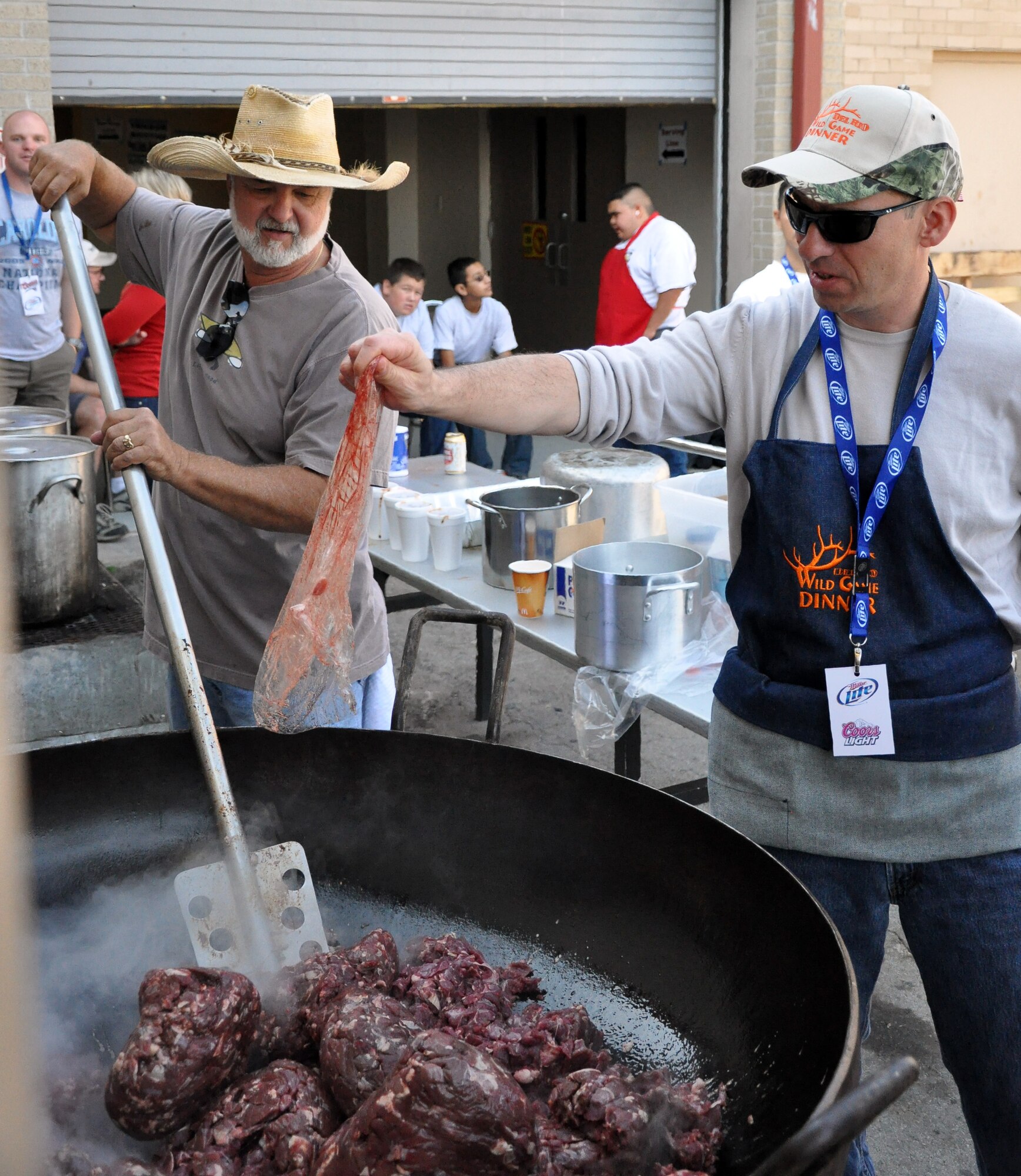 LAUGHLIN AIR FORCE BASE, Texas— 47th Flying Training Wing Commander Col. Tom Murphy assists in cooking meat at the Del Rio Civic Center Dec. 3 for the Del Rio Chamber of Commerce Wild Game Dinner. More than 70 volunteers for the dinner helped cook, serve and clean for the event, which consisted of a meal and gun raffle. (U.S. Air Force photo/Joel Langton)
