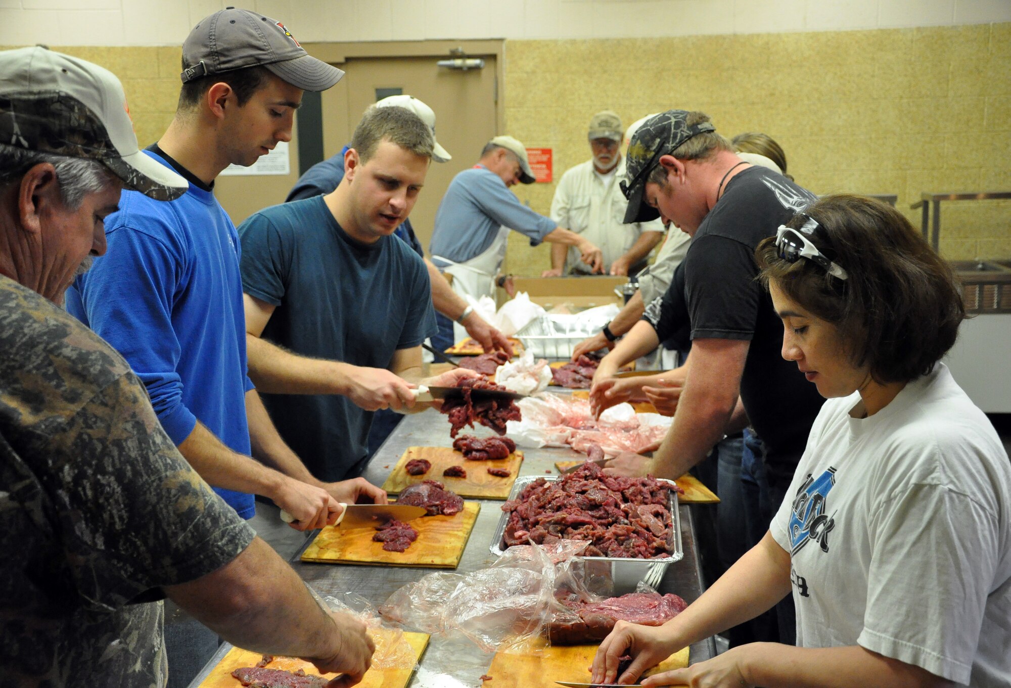 LAUGHLIN AIR FORCE BASE, Texas— Volunteers from Laughlin and Del Rio prep meat for cooking at the Del Rio Civic Center Dec. 3 for the Del Rio Chamber of Commerce Wild Game Dinner. These individuals were among 70 volunteers for the dinner that helped cook, serve and clean for the event, which consisted of a meal and gun raffle. (U.S. Air Force photo/Joel Langton)