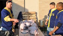 LAUGHLIN AIR FORCE BASE, Texas— Chief master sergeants from Laughlin prep turkeys to be deep fried at the Del Rio Civic Center Dec. 3. The chiefs were among 70 volunteers for the Del Rio Chamber of Commerce Wild Game Dinner that helped cook, serve and clean for the event, which consisted of a meal and gun raffle. (U.S. Air Force photo/Joel Langton)