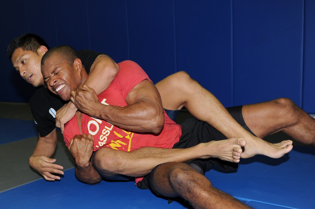 Senior Airmen Kevin Buenavides and Monroe McAnuff, Mixed Military Combative class students, practice maneuvers during the combative class at Langley Air Force Base, Va., Dec. 6, 2011. Based on the Modern Army Combatives Program, the program is designed to arm Airmen with the skills to protect themselves in case they are unarmed and in close combat with an enemy. (U.S. Air Force photo by Staff Sgt. Antoinette Gibson/Released)

