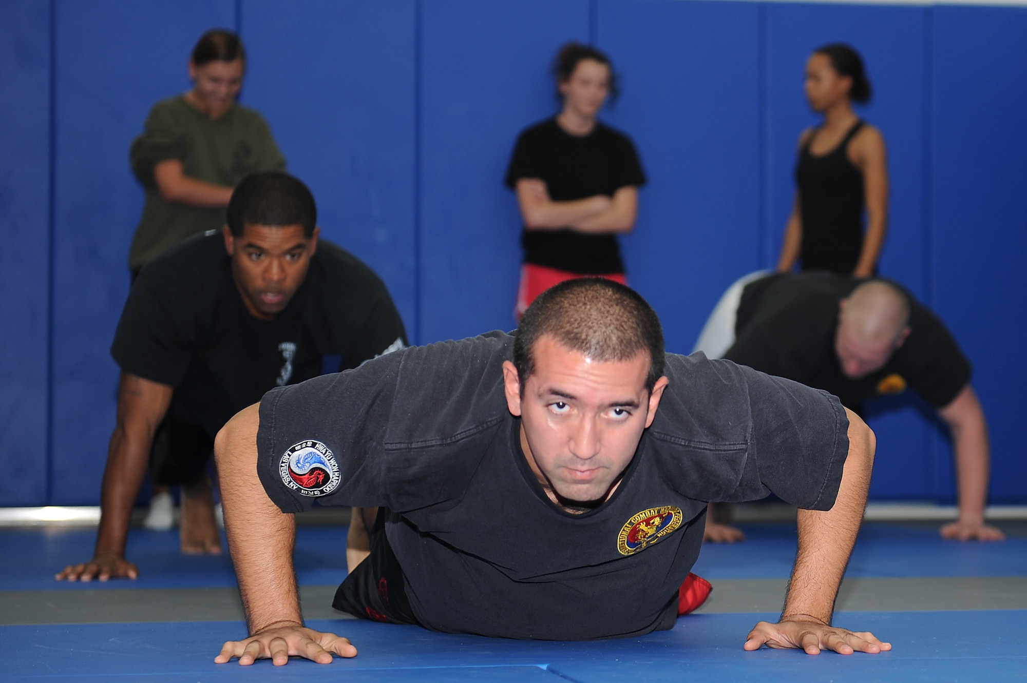 Staff Sgt. Adam Negron, a mixed military combatives instructor, demonstrates maneuvers during the Mixed Military Combatives class at Langley Air Force Base, Va., Dec. 6, 2011. The classes are beginner-friendly, opening with basic instruction, and participants use protective gear to stay safe during the sessions. (U.S. Air Force photo by Staff Sgt. Antoinette Gibson/Released)