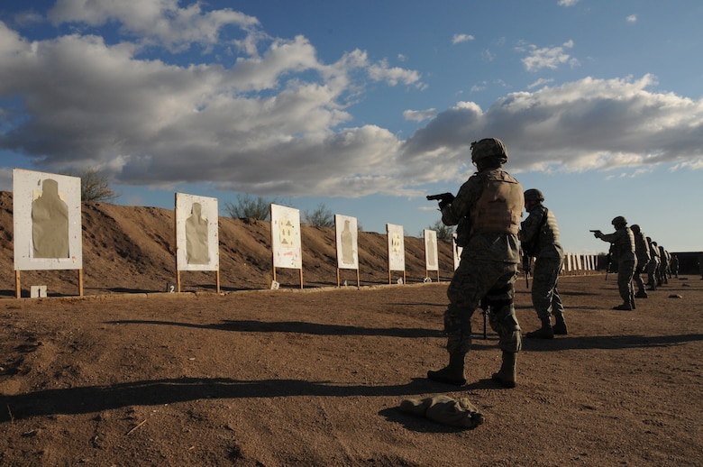 Members of the 161st Security Forces Squadron practicing transitioning to the handgun during weapons qualification Dec. 5, 2011, at the National Guard training range in Florence, Ariz. Beginning Dec. 1, 2011, all Airmen are required to perform in the modernized rifle qualification course which comprises movement while engaging targets to better train and equip Airmen. (U.S. Air Force photo/Tech. Sgt. Susan Gladstein)