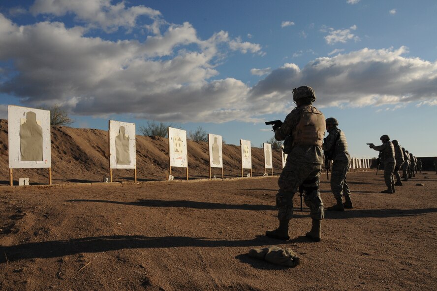 Members of the 161st Security Forces Squadron practicing transitioning to the handgun during weapons qualification Dec. 5, 2011, at the National Guard training range in Florence, Ariz. Beginning Dec. 1, 2011, all Airmen are required to perform in the modernized rifle qualification course which comprises movement while engaging targets to better train and equip Airmen. (U.S. Air Force photo/Tech. Sgt. Susan Gladstein)