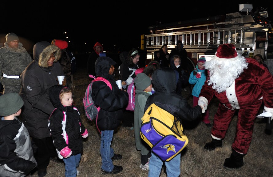 Team McConnell families greet Santa Claus during the wing Christmas tree lighting celebration at McConnell Air Park Dec. 1, 2011, McConnell Air Force Base, Kan. Santa made a surprise visit during the celebration, arriving on a McConnell fire truck. (U.S. Air Force photo/ Airman 1st Class Laura L. Valentine)