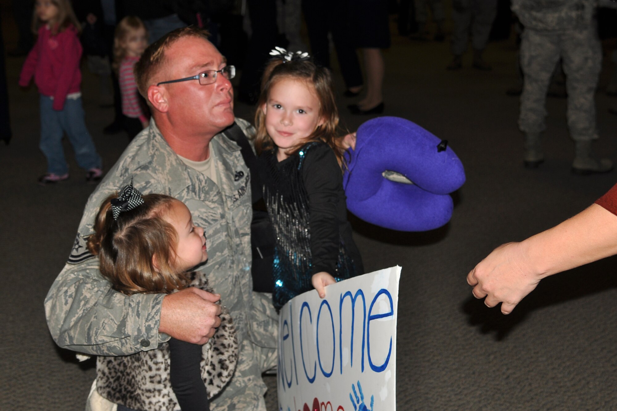 U.S. Air Force Tech. Sgt. Joshua Wendt, an aerospace ground equipment mechanic assigned to the 707th Maintenance Squadron, has an emotional reunion with his daughters Ella, Eden and wife, Monica in Hoban Hall at Barksdale Air Force Base, La., Dec. 4, 2011. Wendt returned from a 126 day deployment to Andersen Air Force Base on Guam. Eight Reserve Airmen from the 707th MXS, 707th Aircraft Maintenance Squadron and the 343rd Bomb Squadron were deployed to Guam to support Air Force operations.  (U.S. Air Force photo by Betty Stephens/Released)