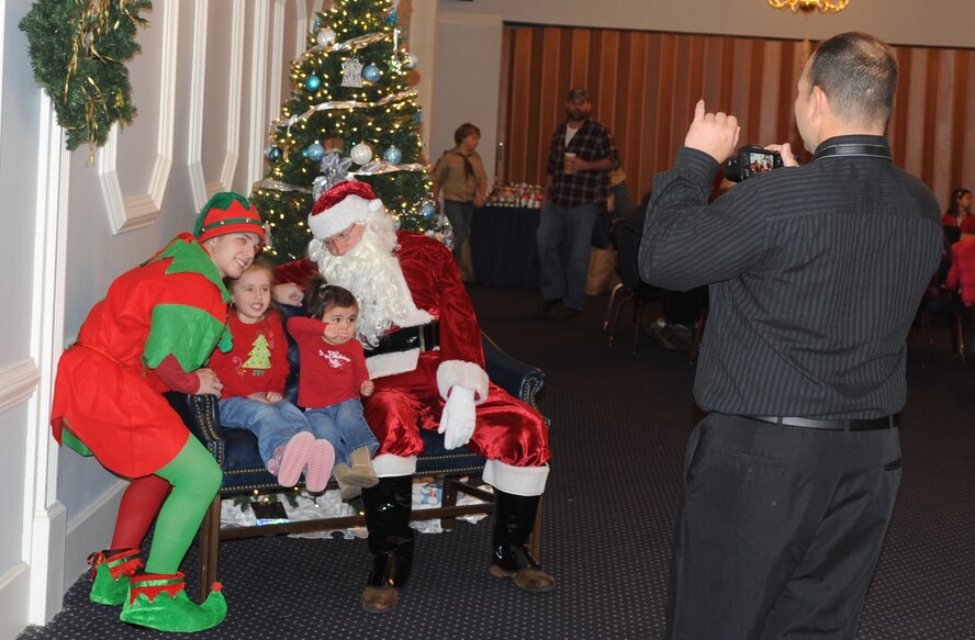 Santa Claus and his elf pose for a picture during Breakfast with Santa event, hosted by the 4th Fighter Wing Top 3 group at Seymour Johnson Air Force Base, N.C., Dec. 3, 2011. The event occurs every year and is designed to give children the opportunity to see Santa Claus and spread holiday cheer. (U.S. Air Force photo by Senior Airman Gino Reyes)