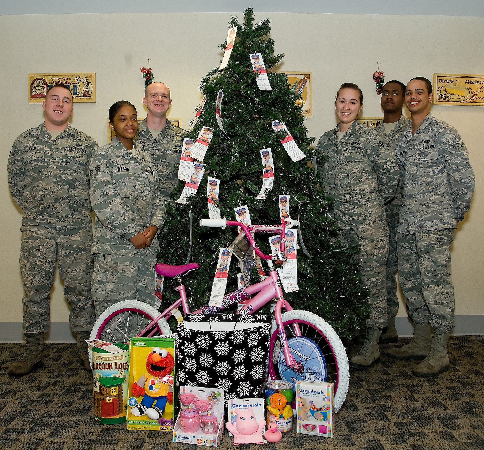 Members of the Patterson Dining Facility gather around the Salvation Army Angel Tree and donated gifts Dec.  2, 2011, at Dover Air Force Base, Del. The Patterson Dining Facility partnered with the Salvation Army of Delaware to donate gifts to children in need. Members wishing to donate can select a tag that includes gender, age, and gifts the child needs, and return the unwrapped gift to the dining facility by Dec. 12, 2011. (U.S. Air Force photo by Adrian R. Rowan)

