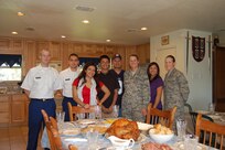 Chief Master Sgt. Jose Lopez (center with cap), Air Education and Traning Command propulsion chief, and his family host two Soldiers from Joint Base San Antonio-Fort Sam Houston, Privates First Class Benjamin Markland (far left) and Albert Macias, and two Airmen from JBSA-Lackland, Airmen Basic Brittany Osgood and Allie Skallerud, in support of Operation Home Cooking Nov. 24.