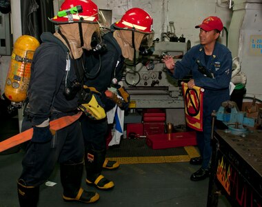 Chief Petty Officer Eugene Ruelos instructs Sailors on the proper procedure for entering a space that had reports of fire during a ship-wide survivability training aboard the Arleigh Burke-class guided-missile destroyer USS Stethem (DDG 63). Stethem is operating in the western Pacific region. (U.S. Navy photo/Petty Officer 3rd Class Matthew Cole)