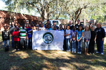 Lieutenant Col. Randall Bishop (sixth from left) and  Master Chief Petty Officer Billy Cady and other members of the 628th Civil Engineer Squadron, stand with members of the South Carolina Forestry Commission and students and faculty members during an Arbor Day ceremony at Hunley Park Elementary School Dec. 2. This is the 16th year JB Charleston has been a member of the Tree City USA foundation. To become a Tree City USA member, a community most meet four annual standards:  a tree protection board or manager, a tree care ordinance, a comprehensive community forestry program, and an Arbor Day observance.  Bishop is the 628 CES commander and Cady is the JB Charleston - Weapons Station command master chief.  (U.S. Air Force photo/ Staff Sgt. Nicole Mickle) 