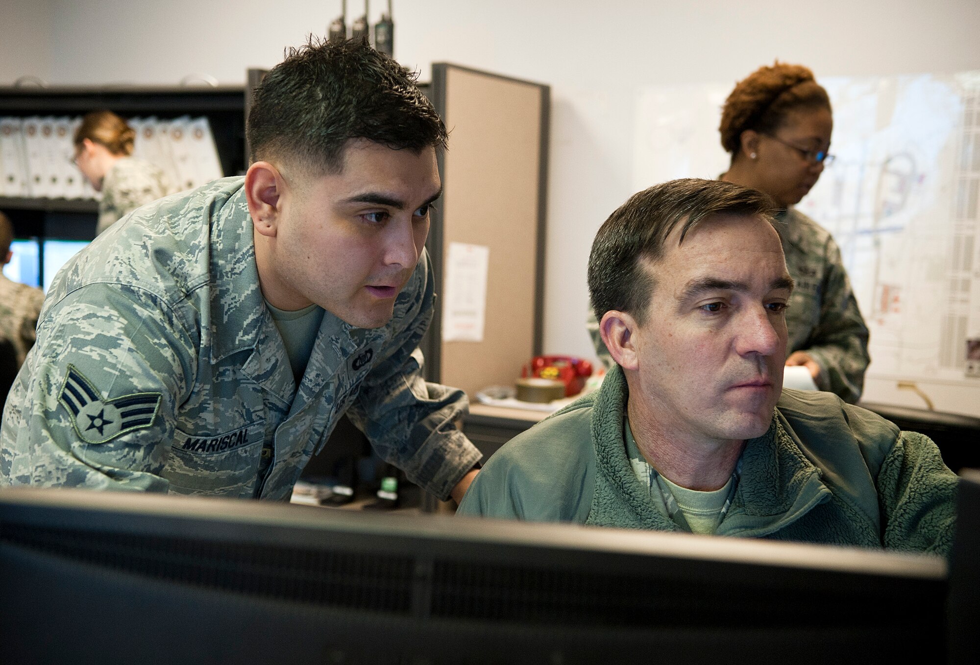 Senior Airman Daniel Mariscal, 3rd Operations Support Squadron airfield management operations supervisor, shows Chief Master Sgt. Steven Bohannon, 3rd Wing command chief, how to input visual flight rules into the system at Base Operations Nov. 30, 2011.  The command chief visits shops throughout the 3rd Wing to get the perspectives of the Airmen that work there.  (U.S. Air Force photo/Staff Sgt. Zachary Wolf)