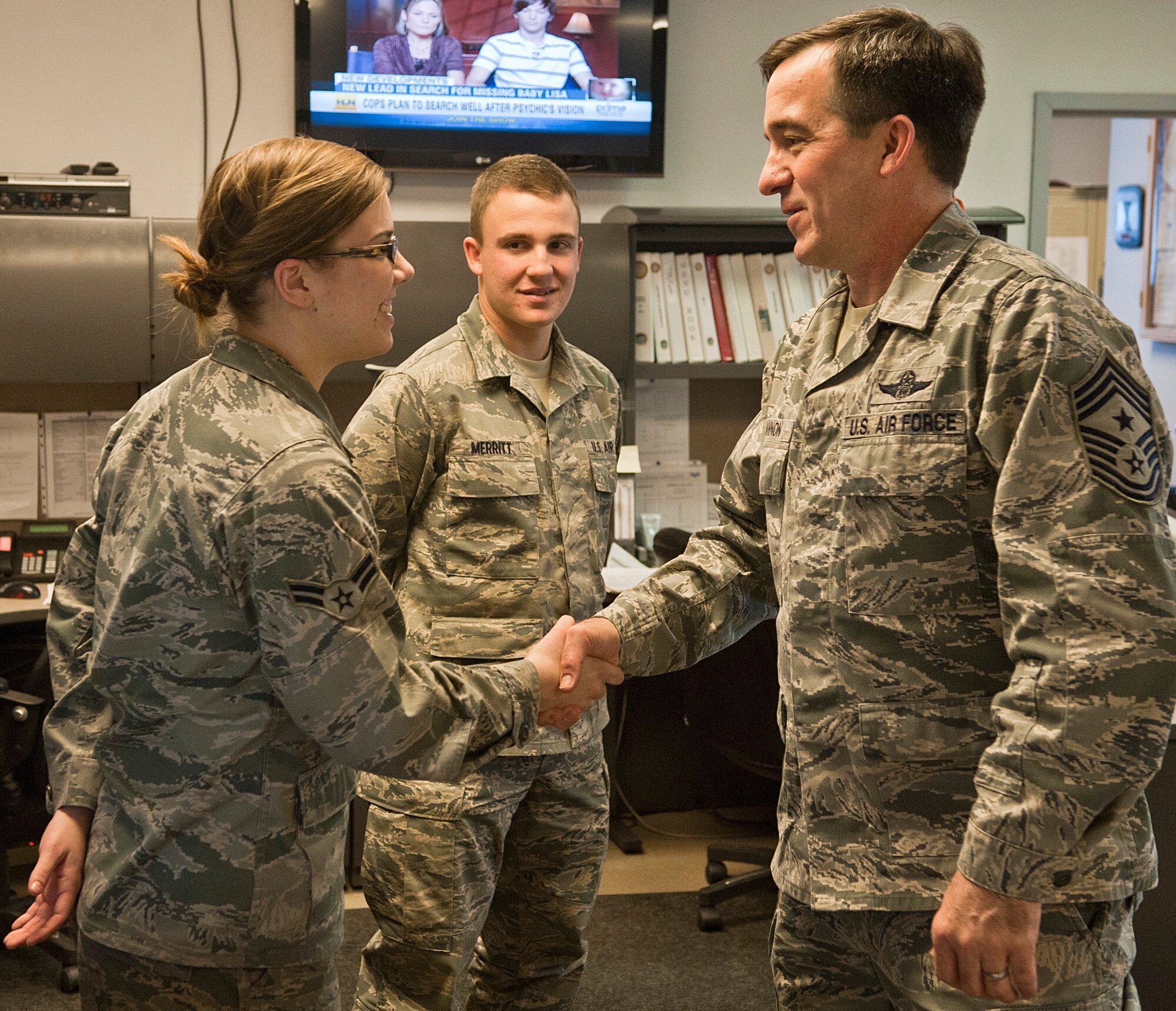 Chief Master Sgt. Steven Bohannon, 3rd Wing command chief, presents Airman 1st Class Aubrey Gregoire, 3rd Operations Support Squadron airfield management operations coordinator, with a coin at Base Operations Nov. 30, 2011.  The command chief visits shops throughout the 3rd Wing to get the perspectives of the Airmen that work there.  (U.S. Air Force photo/Staff Sgt. Zachary Wolf)