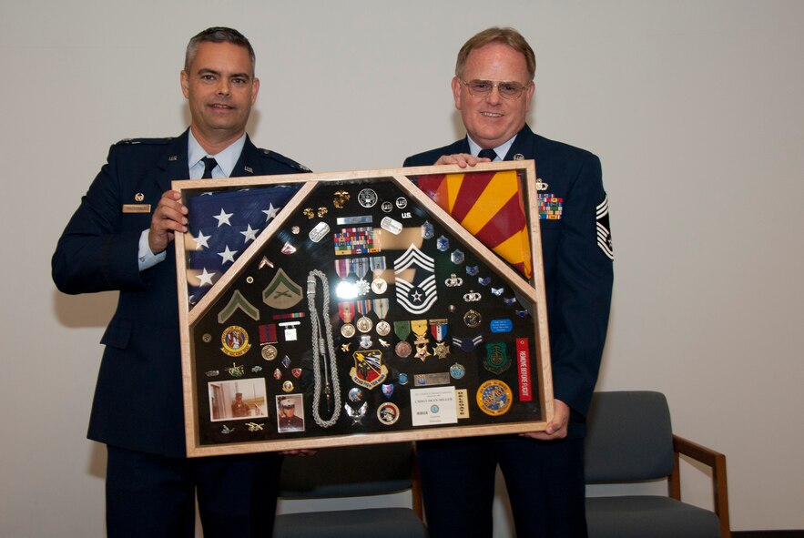 Lt. Col. Andrew MacDonald, 162nd Operations Group commander, presents a shadowbox to Chief Master Sgt. Dean Miller at his retirement ceremony Dec. 3. (U.S. Air Force photo/Master Sgt. Dave Dave Neve)