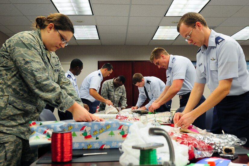 U.S. Air Force officers wrap gift donations for the Angel Tree Program at Langley Air Force Base, Va., Dec. 5, 2011. Volunteers spend three days wrapping presents before they are shipped children in need.  (U.S. Air Force photo by Airman 1st Class Kayla Newman/Released)