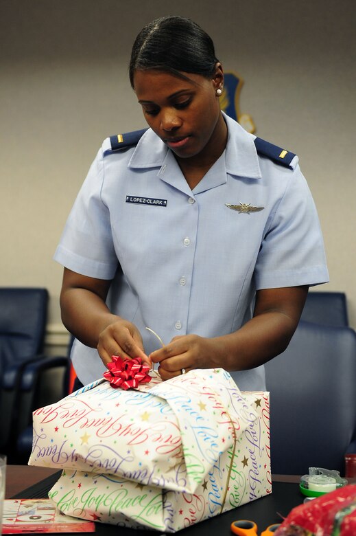U.S. Air Force 2nd Lt. Ashley Lopez-Clark, 633rd Communications Squadron communications focal point officer in charge, ties a ribbon around two presents that will be given to an underprivileged child during the Angel Tree Wrapping party at Langley Air Force Base, Va., Dec. 5, 2011. Presents were bought for children from list posted on Langley’s Angel Tree.  (U.S. Air Force photo by Airman 1st Class Kayla Newman/Released)