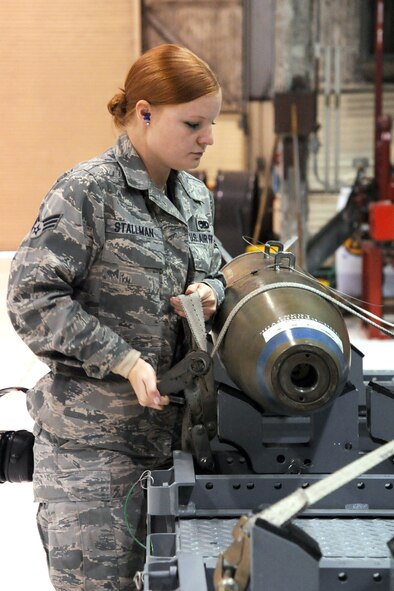 Senior Airman Brittany Stallman, 4th Aircraft Maintenance Squadron standardization load crew member, checks the strap securing an inert bomb during an evaluation on Seymour Johnson Air Force Base, N.C., Nov. 30, 2011. Stallman is responsible for evaluating load crews to ensure they are loading and unloading weapons properly. Stallman hails from Santa Clause, Ind. (U.S. Air Force photo by Senior Airman Whitney Stanfield)  