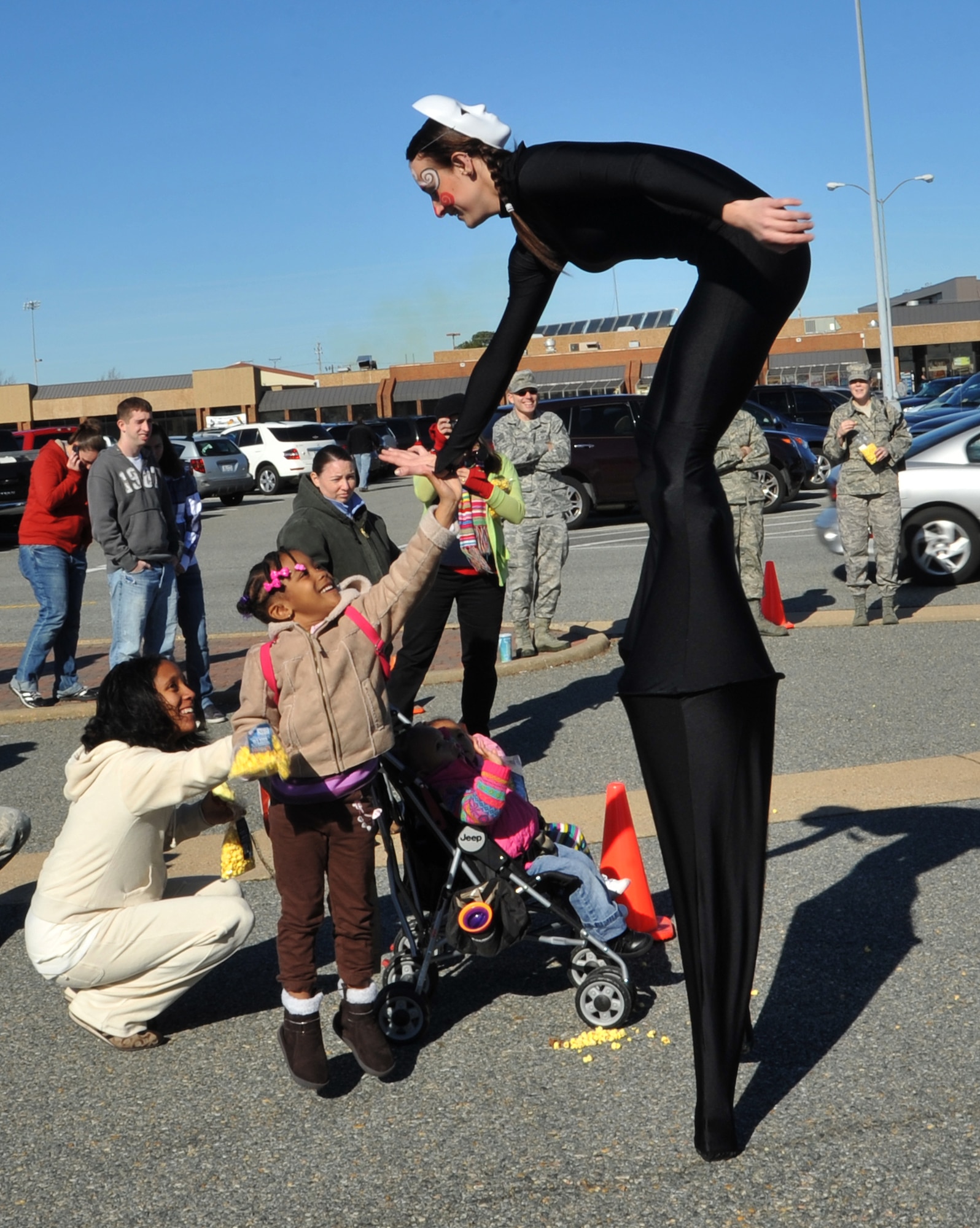 Naomi Gipson gives Britainy Dibbs, a Cirque du Soleil promotional performer, a high five at Langley Air Force Base, Va., Dec. 2, 2011. Cirque du Soleil acrobats will perform in the "Quidam" showat the Hampton Coliseum from Dec. 7-11. (U.S. Air Force photo by Airman 1st Class Camilla Griffin/Released)