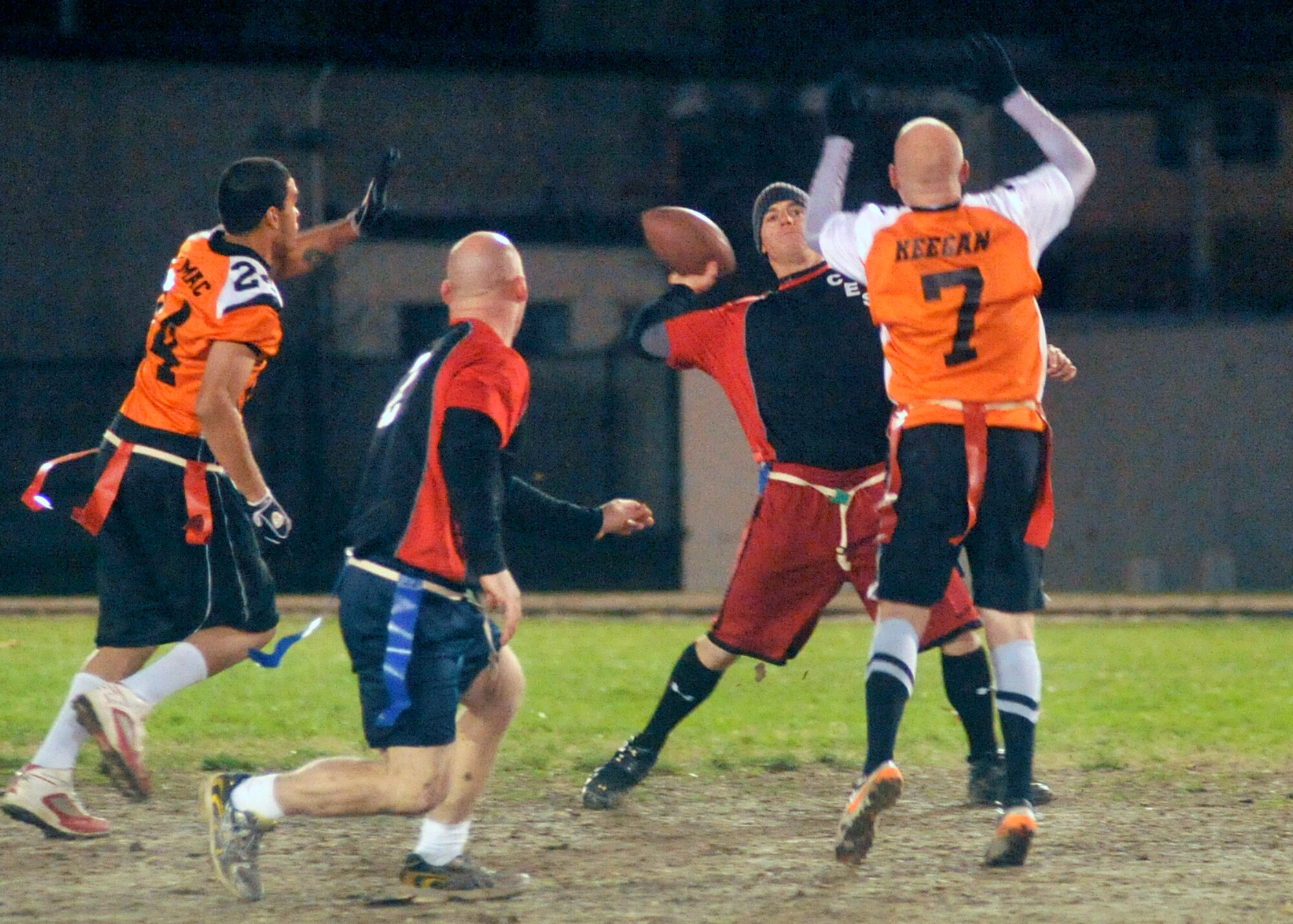 436th Civil Engineer Squadron quarterback/coach Steven Peaper throws a pass while 436th Med Group defenders to attempt to block during the base flag-football championship on Dec. 1, 2011 at Dover Air Force Base, Del. The Med Group defeated CE 34-27 and 25-18 to win the championship. (U.S. Air Force photo by Tech. Sgt. Chuck Walker)
