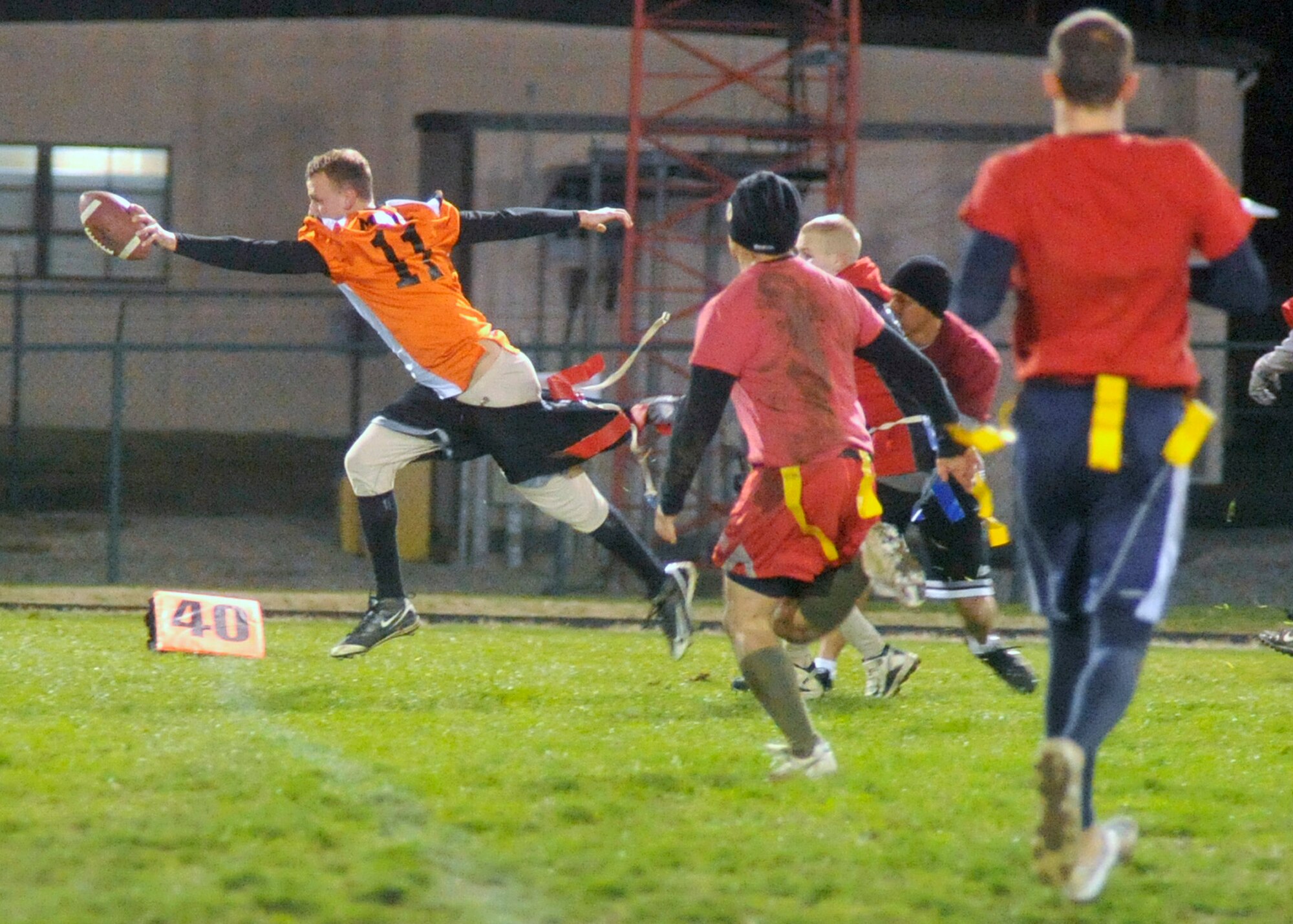 436th Med Group quarterback/coach Ian Money stretches the ball across the goalline for a touchdown as 436th Civil Engineer Squadron defenders attempt to pull his flag during the base flag-football championship on Dec. 1, 2011 at Dover Air Force Base, Del. The Med Group defeated CE 34-27 and 25-18 to win the championship. (U.S. Air Force photo by Tech. Sgt. Chuck Walker)