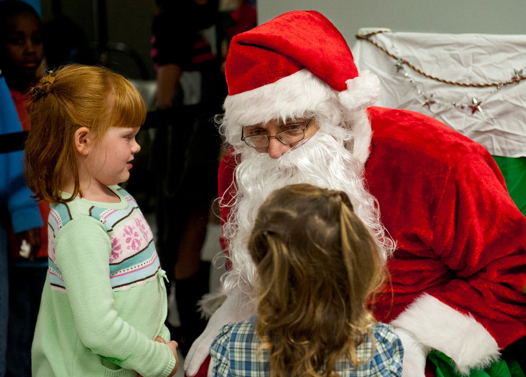 Santa listens to what children want for Christmas at the West Gate chapel Dec. 2 after the official tree lighting ceremony at Eglin Air Force Base, Fla. The ceremony included carols sung by Eglin Elementary students and the announcement of the Christmas card contest winners. (U.S. Air Force photo/Sachel Seabrook)