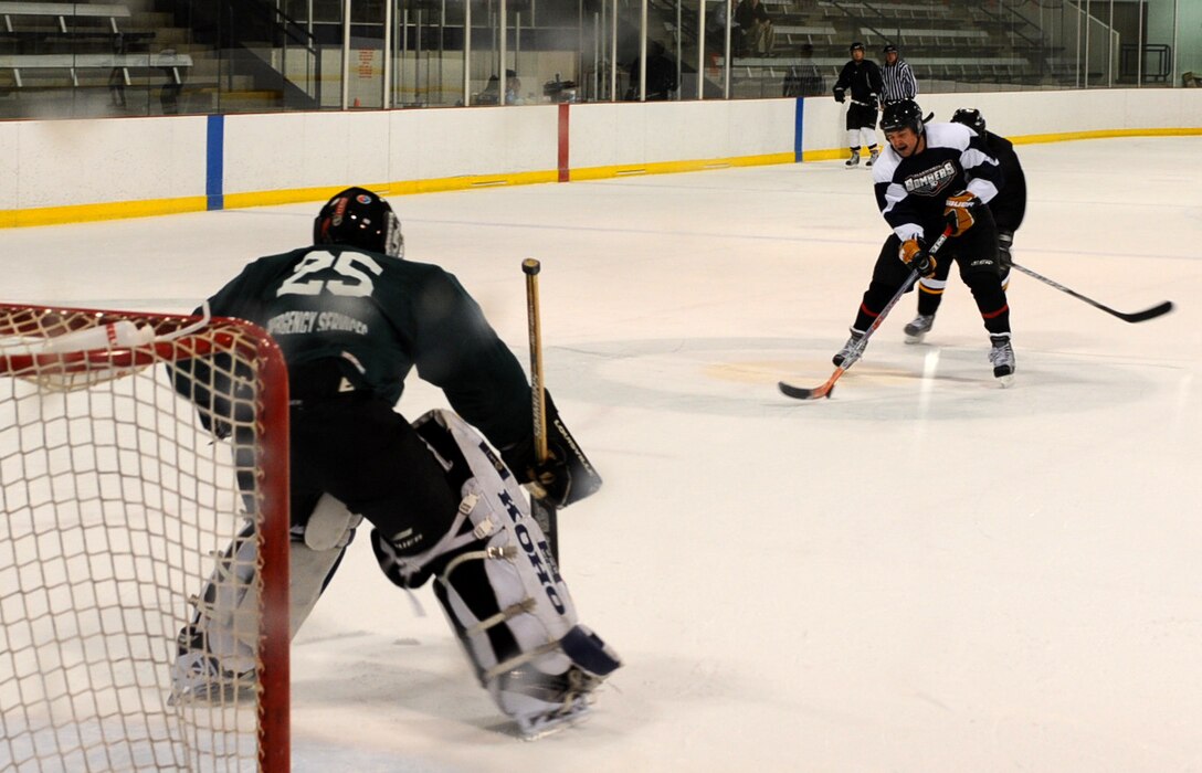 Ellsworth Bombers Division C team member Master Sgt. Alan Malone, 28th Logistics Readiness Squadron vechicle operations supervisor, lines up a shot after a break against the opposing team’s goalie at the Roosevelt Ice Park Arena in Rapid City, S.D., Nov. 22, 2011. The Ellsworth Bombers which includes more than 27 Air Force Airman from Ellsworth, are wrapping up the current season. (U.S. Air Force photo by Airman 1st Class Zachary Hada/Released)