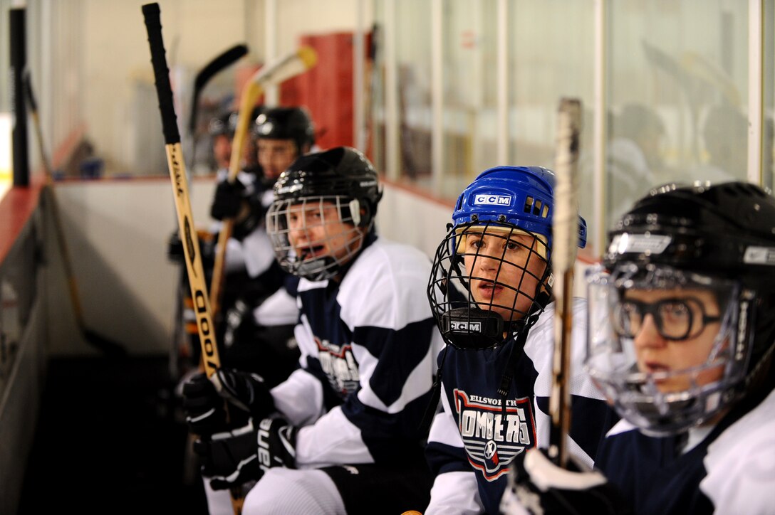 Senior Airman Taylor Johnson, 28th Medical Support Squadron dental assistant, looks on and supports her team during a game against the Guiness Division C team at the Roosevelt Ice Park Arena in Rapid City, S.D., Nov. 22, 2011. The players rotate on and off the bench to keep fresh players on the ice. (U.S. Air Force photo by Airman 1st Class Zachary Hada/Released)
