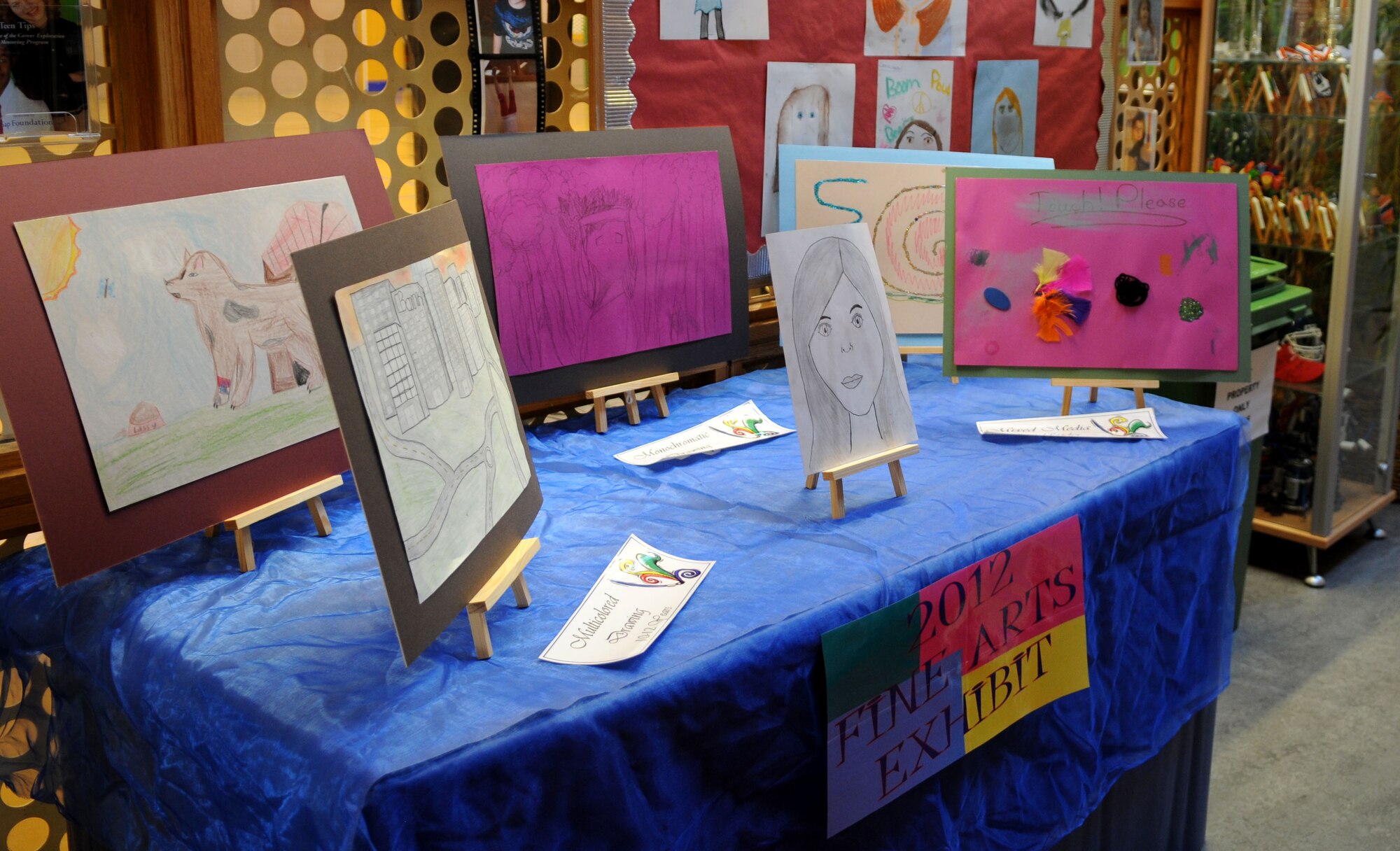 RAF MILDENHALL, England -- A display table showcases entries into the Boys & Girls Club of America 2012 National Fine Arts Exhibit at the youth center here, Dec. 5, 2011. The program was open to youth ages 6 to 18 and the winners from the 10 categories will have their artwork displayed at the Bob Hope Community Center Dec. 12 through 16. Afterward, the winning entries will be sent to Ramstein Air Base, Germany, to compete at the regional level.  Regional winners will then be sent to the BGCA’s national headquarters to compete at the BGCA National Fine Arts Exhibit in Atlanta. (U.S. Air Force photo/Senior Airman Rachel Waller)