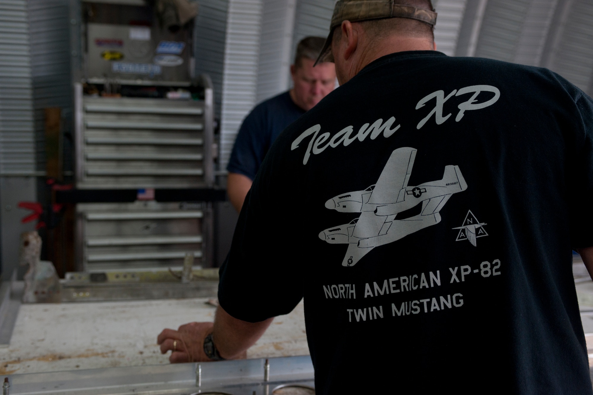 A member of the B-25 Group sets down an aircraft part on a work table in a hangar in Douglas, Ga., Oct. 18, 2011. Tom Reilly, owner of the B-25 Group, hired a small group of aircraft mechanics to help with the restoration of an XP-82 Twin Mustang. (U.S. Air Force photo by Airman 1st Class Jarrod Grammel/Released) 
